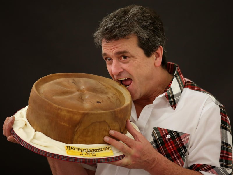 Les McKeown eating a giant birthday cake in the style of a Scotch pie as he celebrates his birthday during the World Scotch Pie Championship at the Carnegie Conference Centre in Dunfermline.