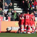 Crawley Town players celebrate in front of Forest Green Rovers fans