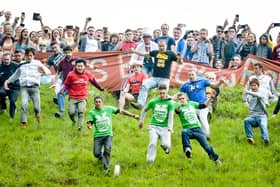 Participants tumble after the Double Gloucester cheese as it hurtles down Coopers Hill, Gloucestershire, in the annual Cheese Rolling competition. Photo credit: Ben Birchall/PA Wire