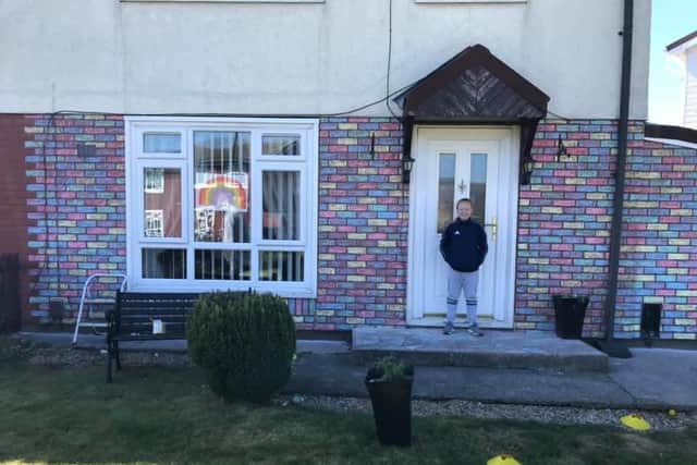 Mia Stevenson, 10, in front of her rainbow-coloured house