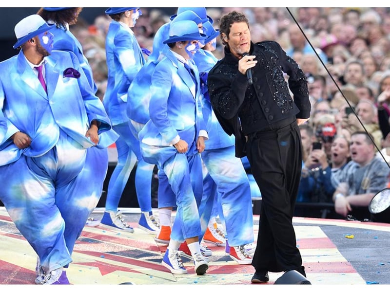 Howard Donald leads a team of dancers around the stage.