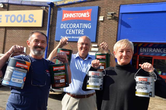 Johnstone's Decorating Centre manager John Dingwall (left) alongside St Michael's Community Centre secretary Sue Ferguson and Cllr Michael Dixon holding some of the tins of donated paint.