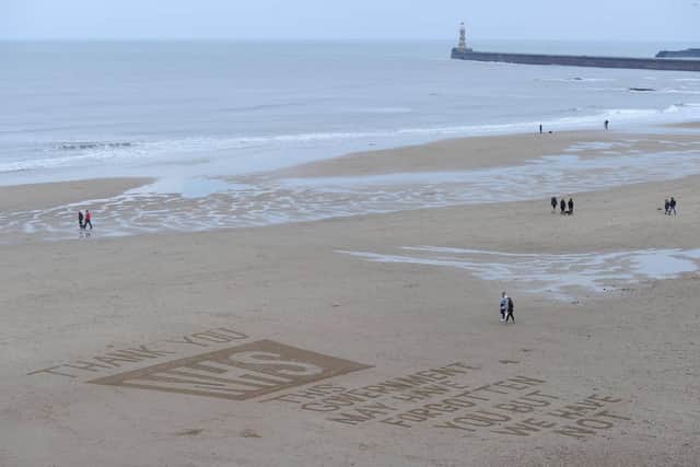 A tribute to the NHS is drawn in the sand at Roker beach in Sunderland.