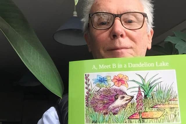 Author Ian Mole with a copy of his book A, Meets B in a Dandelion Lake.