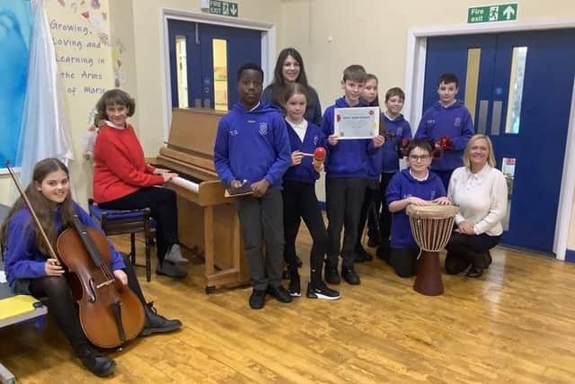 (left to right) Elizabeth Paget, Emma Mapplebeck and Laura Parkin celebrating their Music Mark award with pupils from St Mary’s Catholic Primary School..