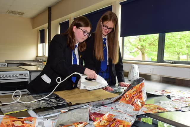 (left) Marcie Sloan, 13, and Katie Belford, 12, using an iron to fuse the crisp packets together.