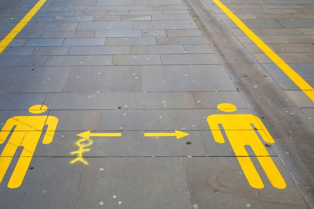 Signs on the pavement advise shoppers to maintain social distancing guidelines. Picture: Geoff Caddick/AFP via Getty Images.
