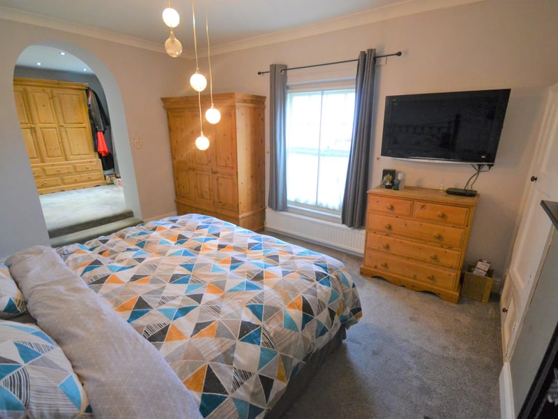 Large, front-facing double bedroom with feature open-cast fireplace and open-plan access to the dressing room.
