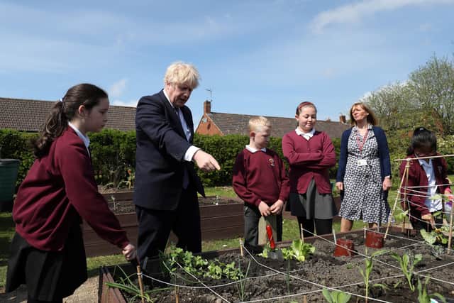 Prime Minister Boris Johnson helps out in the vegetable garden during a visit to Cleves Cross Primary school in Ferryhill, County Durham. Picture date: Thursday May 13, 2021.