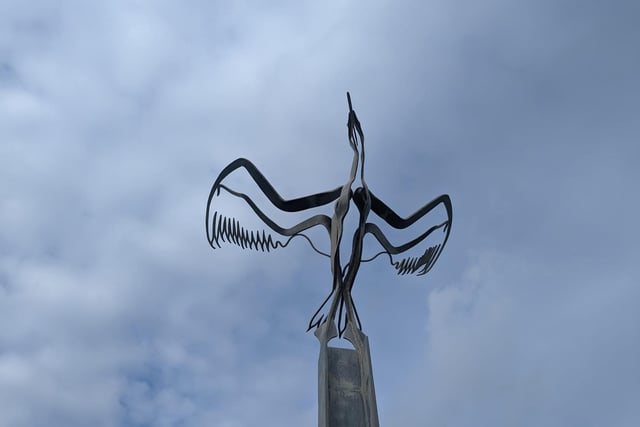 A series of sculptures, Taking Flight is at the end of North Dock promenade. Craig Knowles designed a series of upright steel beams running along its length, each varying from the last. The steel has been beaten and forged to create sinuous forms which gradually merge to form a cormorant's flight.