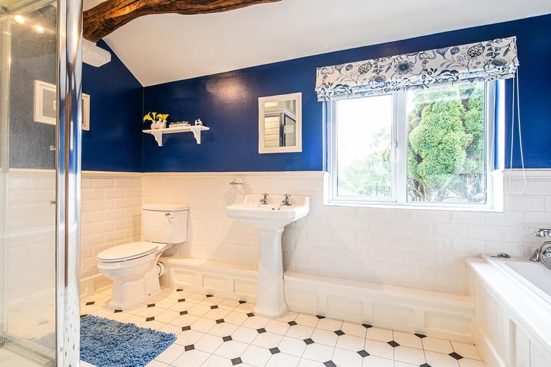 The bathroom has a white suite including a bathtub and separate shower enclosure.