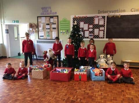 Pupils at Plains Farm Academy, in Sunderland, with some of the gifts that the school's community has donated this Christmas.