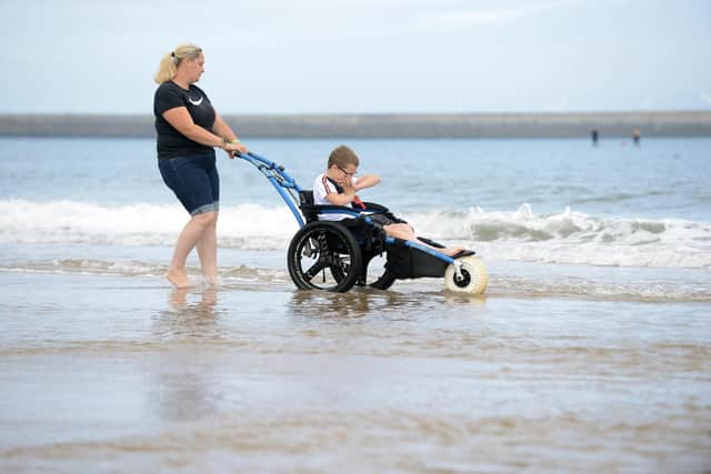 Jack Rowntree, 11 with mum Stacey Newton with the beach accessible wheelchair for the Together for Children Sunderland beach party.