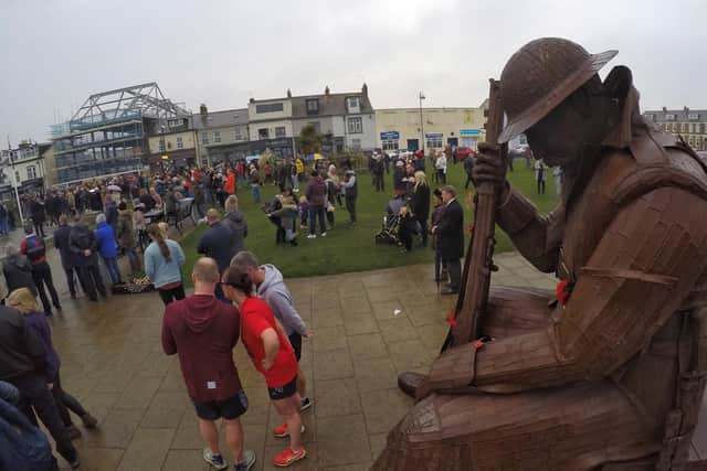 People pay their respects beside the Tommy statue in Seaham.
