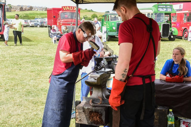 William Ridley (10) of Hetton helping blacksmith Darren Witty  at Hetton Carnival, Hetton Country Park, on Saturday