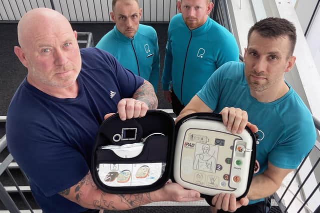 Allan Scott 58 (left) with PureGym staff (left to right) Dan Knott, Andrew Boal-Wallace and Gary Lee who used the defibrillator Alan and Andrew are holding to save his life. 

Picture by FRANK REID