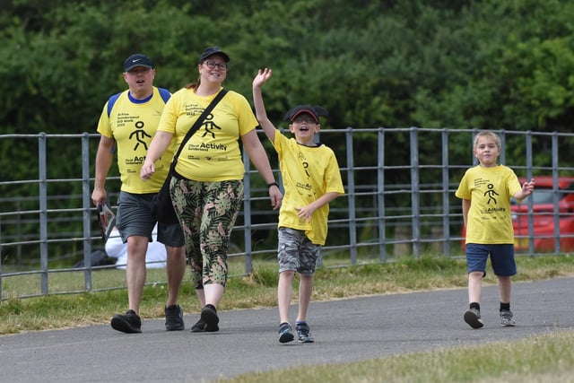 A young walker gives us a wave as he plods on with his family. Go on!