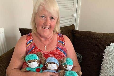 Margaret Robson and some of the teddy bears she has knitted to support the NHS.