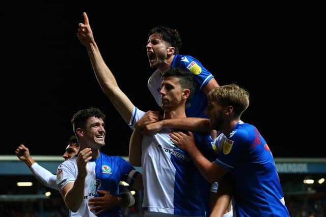 Daniel Ayala of Blackburn Rovers celebrates with team mates Lewis Travis and Daniel Butterworth after scoring their team's first goal during the Sky Bet Championship match between Blackburn Rovers and Hull City at Ewood Park on September 14, 2021 in Blackburn, England. (Photo by Alex Livesey/Getty Images)
