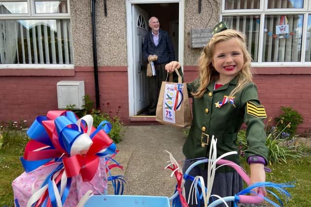 The schoolgirl delivers a bag of VE Day treats to one of her elderly neighbours.