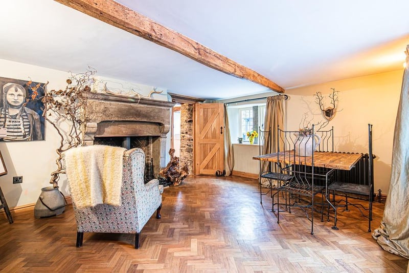 The sitting room has a fireplace and stove, as well as attractive flooring.