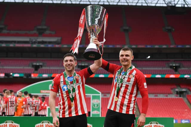 LONDON, ENGLAND - MARCH 14: Lynden Gooch and Max Power of Sunderland celebrate with the Papa John's Trophy after the Papa John's Trophy Final match between Sunderland and Tranmere Rovers on March 14, 2021 in London, England. Sporting stadiums around England remain under strict restrictions due to the Coronavirus Pandemic as Government social distancing laws prohibit fans inside venues resulting in games being played behind closed doors (Photo by Justin Setterfield/Getty Images)