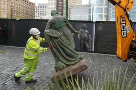 Workers take down a statue of slave owner Robert Milligan at West India Quay, east London as Labour councils across England and Wales will begin reviewing monuments and statues in their towns and cities, after a protest saw anti-racism campaigners tear down a statue of a slave trader in Bristol. Picture by: Yui Mok/PA Wire