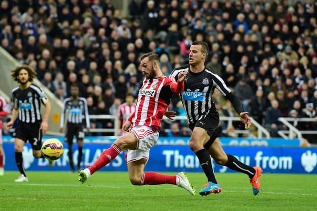 Newcastle United player Steven Taylor looks on as Steven Fletcher of Sunderland fires a shot at goal.