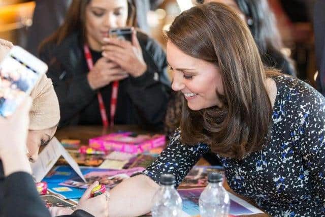 The Duchess of Cambridge receiving a henna tattoo from a member of YAV on a visit to Sunderland in February 2018.