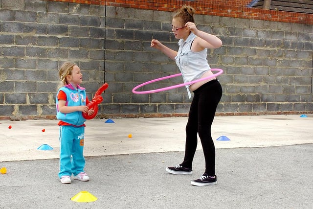 Shamane Magruder, 4, gets a hula-hoop masterclass from 12-year old Holly Hannan at the St. Matthew's Church  "111 years and still standing" event in 2013.
