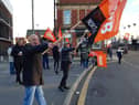 Pickets wave flags for passing motorists
