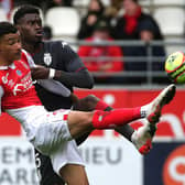 Reims' French forward Hugo Ekitike (L) fights for the ball with Monaco's French defender Benoit Badiashile Mukinayi (R)  during the French L1 football match between Stade de Reims and AS Monaco at Stade Auguste-Delaune in Reims, northern France on November 7, 2021. (Photo by FRANCOIS NASCIMBENI / AFP)