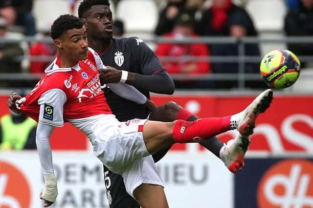 Reims' French forward Hugo Ekitike (L) fights for the ball with Monaco's French defender Benoit Badiashile Mukinayi (R)  during the French L1 football match between Stade de Reims and AS Monaco at Stade Auguste-Delaune in Reims, northern France on November 7, 2021. (Photo by FRANCOIS NASCIMBENI / AFP)