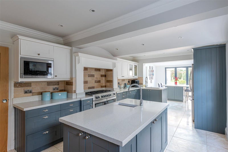 The recently appointed hand painted kitchen includes fitted cupboards and integrated appliances, with a double oven and central island, plus a seating area overlooking the garden.