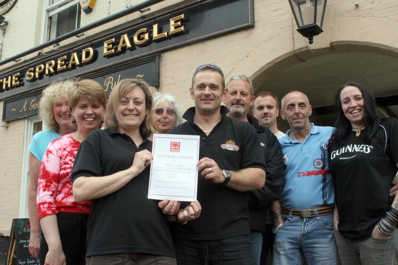 The Spread Eagle landlord and landlady Tom and Jenni Symons pictured with ladies from British Heart Foundation and some of the regulars