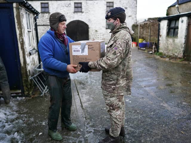 DURHAM, ENGLAND - DECEMBER 05: Trooper Josh Harvey from the Royal Lancers delivers a welfare package to farmer David Eccles as welfare checks are carried out on remote properties in Teesdale that remain without power on December 05, 2021 in Durham, England. Several thousand people in the North East remain without power more than a week after Storm Arwen battered parts of England and Scotland. As the area faces another bout of wet and windy conditions, members of the British Army's Royal Lancers, a cavalry regiment, are conducting welfare checks on affected residents. (Photo by Ian Forsyth/Getty Images)