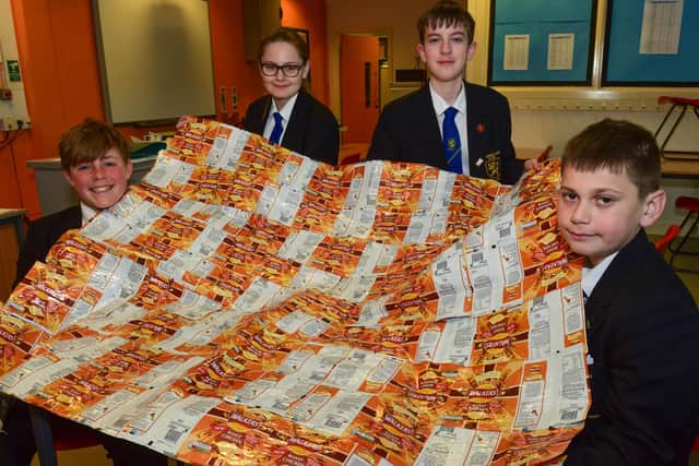 Pupils with one of their foil blankets made out of recycled crisp packets. (left to right) Charlie Hutchinson, 13, Peyton Lancaster, 12, Jay Ferry, 13, and Mitchell Peggie, 13.