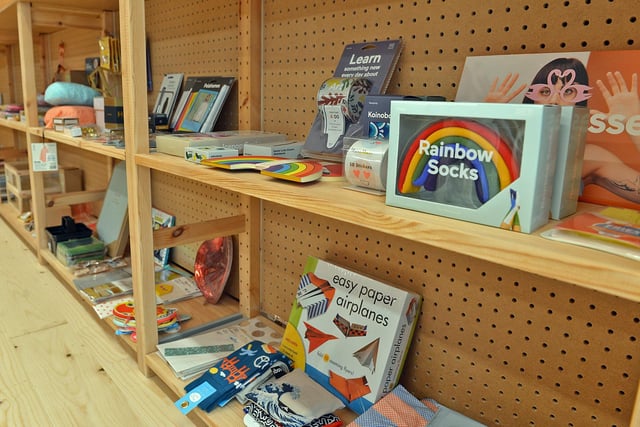 A pair of socks shaped like - and in the colours of - a rainbow can be seen on the shelves.