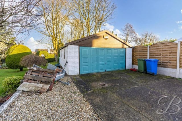 It's fine to focus on the greenery of the garden, but let's not forget the more practical features of the exterior, such as this large, detached garage. Along with the driveway, it offers plenty of space for off-street parking.
