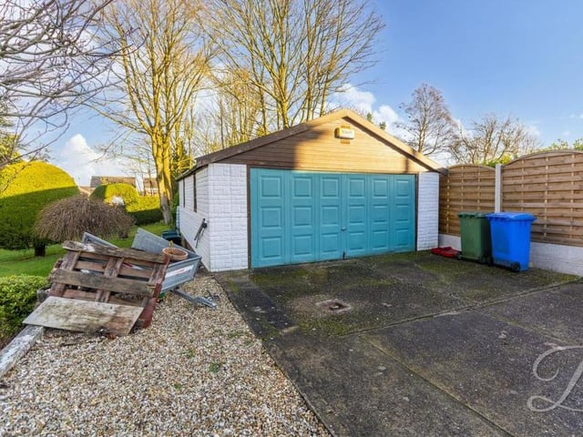 It's fine to focus on the greenery of the garden, but let's not forget the more practical features of the exterior, such as this large, detached garage. Along with the driveway, it offers plenty of space for off-street parking.