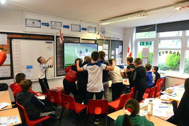 Plains Farm Academy pupils jump up and down in celebration of an England goal.