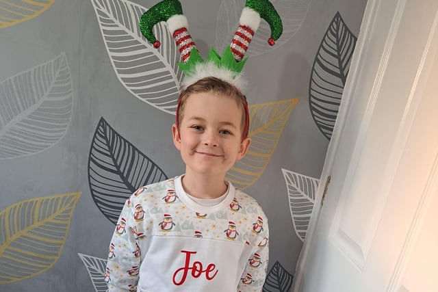 Joe, age 8, getting into the festivities with a Christmas hairband and jumper.