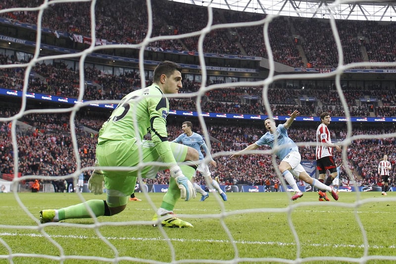 Sunderland's Italian goalkeeper Vito Mannone (L) remains on his line as Manchester City's French midfielder Samir Nasri (R) wheels away to celebrate scoring their second goal during the League Cup final football match between Manchester City and Sunderland at Wembley Stadium in London on March 2, 2014.