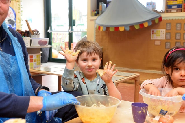 Children at Stepping Stones Day Nursery enjoy getting messy as they prepare their cake mix.