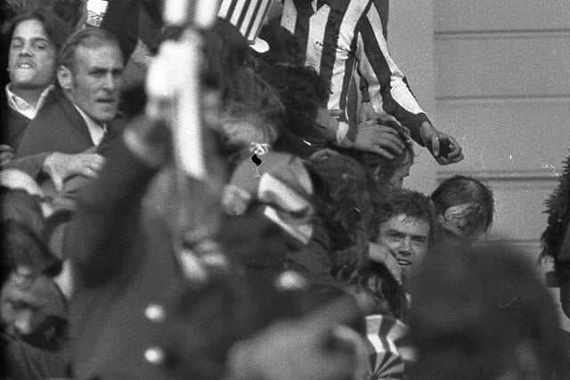 Ron Guthrie, Dick Malone and Ron Guthrie are mobbed on the Wembley steps by jubilant fans.