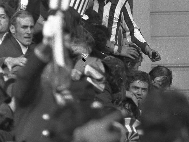 Ron Guthrie, Dick Malone and Ron Guthrie are mobbed on the Wembley steps by jubilant fans.