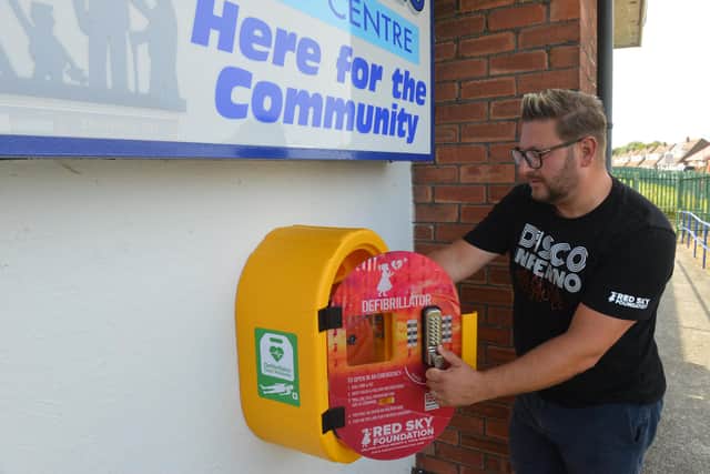 St Michael's Community Centre receive a defibrillator from  Red Sky Foundation founder Sergio Petrucci.