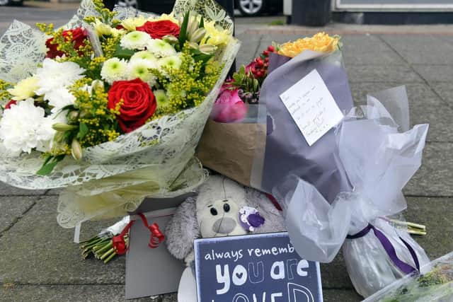 A few of the floral tributes left in memory of Joan Hoggett outside the store where she worked.