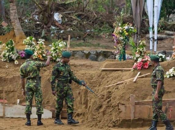 Officers of Special Task Force search for explosives ahead of mass burials at a burial ground for Easter Sunday bomb blast victims in Negombo, Sri Lanka. Picture by PA.