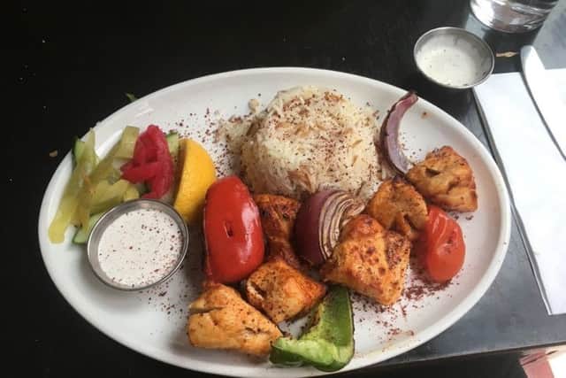 Shish taouk, which is chargrilled skewers of marinated chicken cubes served with garlic sauce, rice and grilled vegetables.
